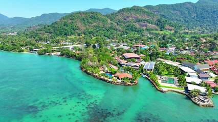 Gorgeous beaches, resorts by the sea, lush mountain forests, and a serene blue sky, all captured from above with a drone. Tourist attractions concept. Trat Province, Thailand. 
