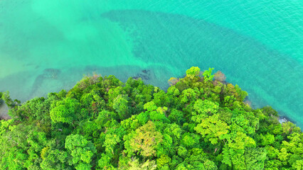 Aerial drone shot reveals a paradise island with emerald rainforests, majestic mountains, and azure...