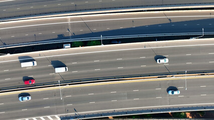 Fototapeta premium Aerial view, Flying above the expansive highway, the drone provides a bird's-eye view of the intricate network of roads, symbolizing progress in transportation. Traffic concept. Bangkok, Thailand. 