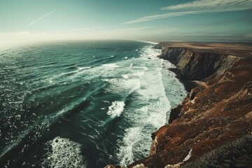 A wide-angle shot capturing the vast ocean meeting rugged cliffs from a high vantage point