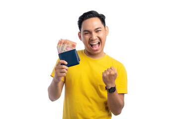 Excited young Asian man holding cash in wallet and raising his fist isolated on white background. Profit and wealth concept