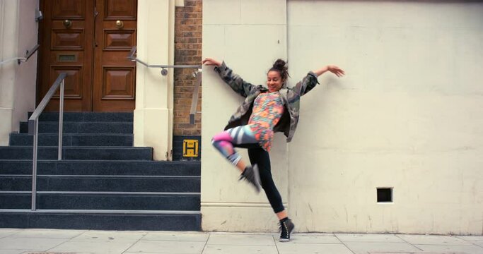 Woman in city, dancing with energy and hip hop outdoor, happy with music and creativity for fun. Rhythm, motion and moving on sidewalk, urban and dancer in streetwear with freedom and performance