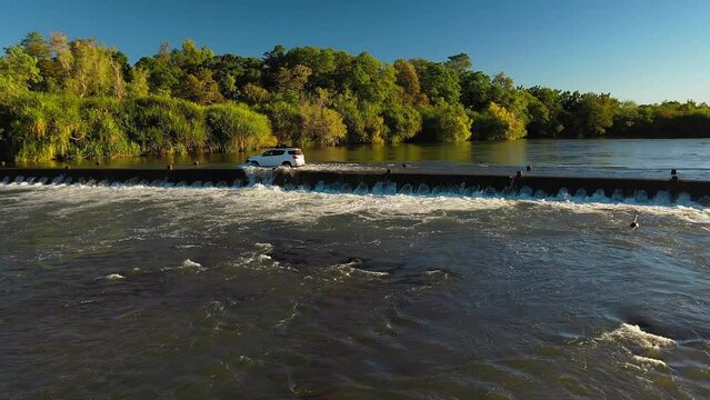 Aerial footage, push in move of a white 4WD crossing, Ivanhoe crossing in Kununurra, Western Australia 