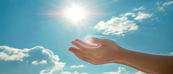 opened both hands fingers of a woman applying reiki healing against the background of a bright sun blue sky and clouds