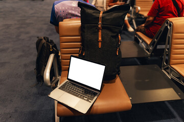 A laptop with blank screen on chair at airport