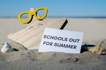 SCHOOLS OUT FOR SUMMER text on paper greeting card on background of funny starfish in glasses summer vacation decor. Sandy beach sun coast. Holiday concept postcard. Getting away Travel Business