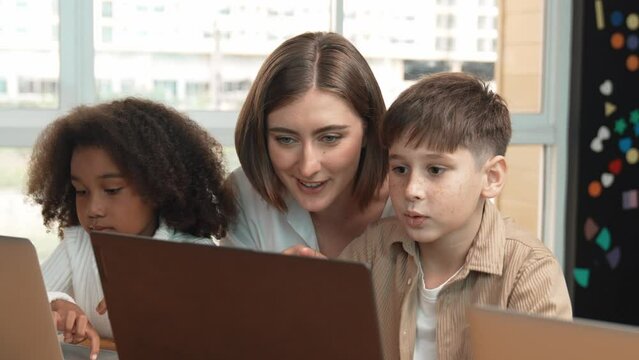 Smart teacher teaching and looking student using laptop at classroom. Professional instructor explained about programing engineering code or prompt while studying and learning program. Erudition.