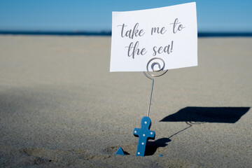 TAKE ME TO THE SEA text on paper greeting card in anchor paper holder and starfish seashell summer vacation decor. Sandy beach sun coast. Holiday concept postcard. Getting away Travel Business concept