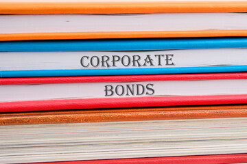 Finance and economics concept. CORPORATE BONDS written on notebooks stacked in a pile - obrazy, fototapety, plakaty