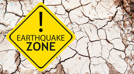 Caution Earthquake Zone Sign on Cracked Rock Background
