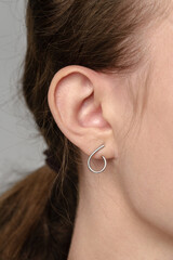 Female ear with earring and hair in ponytail close up