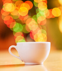 Bokeh, background and cup for coffee or tea, fine china or porcelain with crockery for drink, catering and kitchenware. Color, light and ceramic drinkware for breakfast or break time beverage at cafe