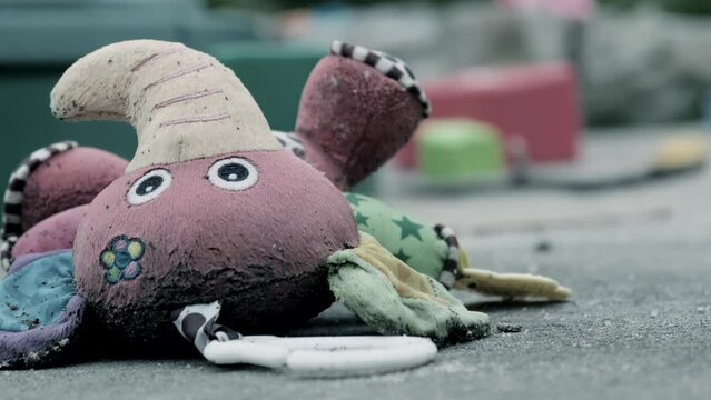 Children's dirty wet toy toy lying on the playground. The concept of lost childhood, or poor communication with children