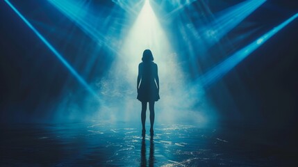A woman standing alone on a stage with spotlights shining down on her.