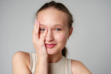 Young Woman Covering Face With Hand on gray background