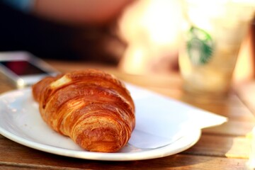 A buttery, flaky pastry originating from France, croissants delight with their golden exterior and soft, airy interior. - obrazy, fototapety, plakaty