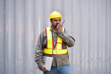 Middle east logistic worker foreman use walkie talkie working at container site	