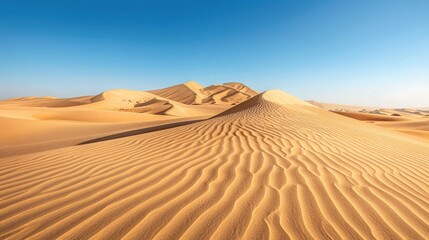 A rugged, desert landscape with towering sand dunes stretching to the horizon under a clear blue sky.