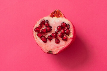 Ripe pomegranate on a pink background, top view
