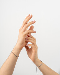 The girl's fingers touch the guy's palm, hands close on a white background.