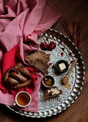 Photo of a beautiful old breakfast tray with bread, butter and honey