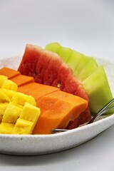 Fresh cut fruits on big bowl. Watermelon, muskmelon and papaya cuts. For buffet menu. on plate with white background.