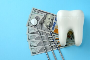 Dollar money bills and tooth model on a bluebackgound with copy space - 794896982