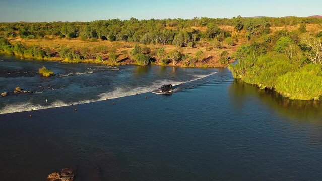 Aerial footage, pan move of a black 4WD crossing, Ivanhoe crossing in Kununurra, Western Australia 