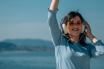woman with headphones enjoying on the beach