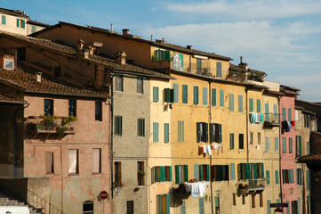 Colorful houses in the city of Siena Italy. Antique Italian houses with shutters. Laundry is drying...