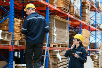 Young employee checking stock In a large cardboard factory