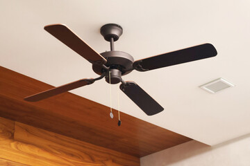 Wooden ceiling fan. Modern room cooling device with speed control. Summer and heat in the room.