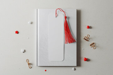 Bookmark with tassel on hardcover book mockup. 3D rendering