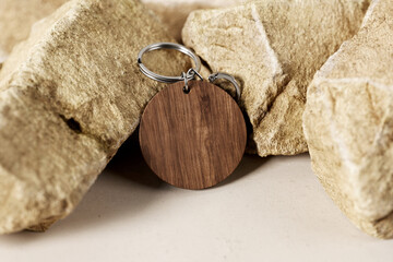 Round wooden key ring near stones mockup. 3D rendering