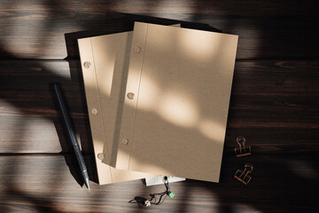 Two kraft screw binding notebooks on the wooden surface mockup. 3D rendering