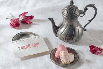 French macaron macaroon cookies in heart and old craft pewter tea or coffee pot  with thank you...
