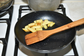 The frying pan is on the gas stove.
