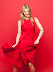 Studio, fashion and dress of woman with dance for winning, achievement and feminine confidence. Female person, happy and smile with celebration for glamour, freedom and chic style on red background