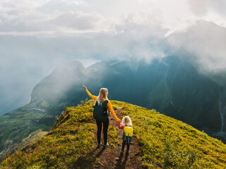Family vacations in mountains - mother and child climbing in Norway together active summer...