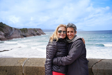 Fototapeta premium mother and daughter smiling looking at camera on a Spanish beach. Two women of the family