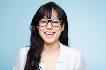Happy, optometrist and portrait of woman with glasses in studio, blue background and mockup space....
