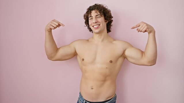 Handsome, confident young hispanic guy pointing at self with a happy smirk, displaying shirtless body over pink isolated wall as symbol of positivity and success.
