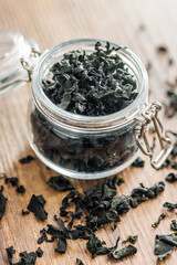 Dried wakame seaweed in jar on wooden table. - 794992701