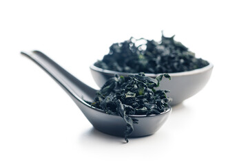 Dried wakame seaweed in spoon isolated on white background. - 794993917