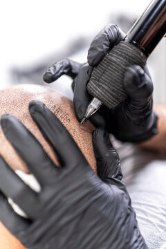 Detalle de maquina de tatuar realizando micropigmentación capilar