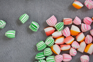 old fashioned colorful sweets scattered on mottled grey with copy space