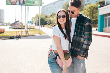 Smiling beautiful woman and her handsome boyfriend. Woman in casual summer clothes. Happy cheerful family. Female having fun. Sexy couple posing in the street at sunny day. In sunglasses