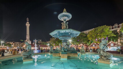 Panorama showing illuminated fountain with holiday decorations at the Rossio Christmas Market...