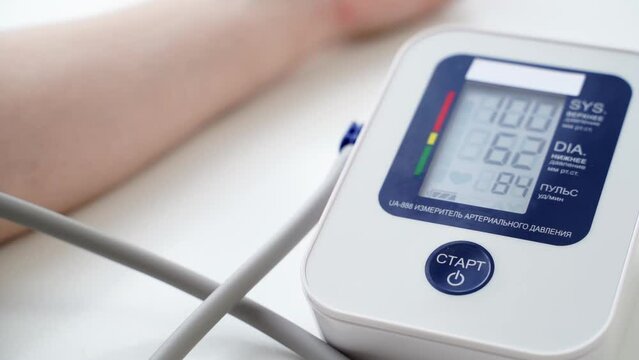 the girl measures blood pressure with a tonometer