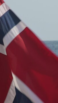 Norwegian flag waving in a beach. 4K Vertical